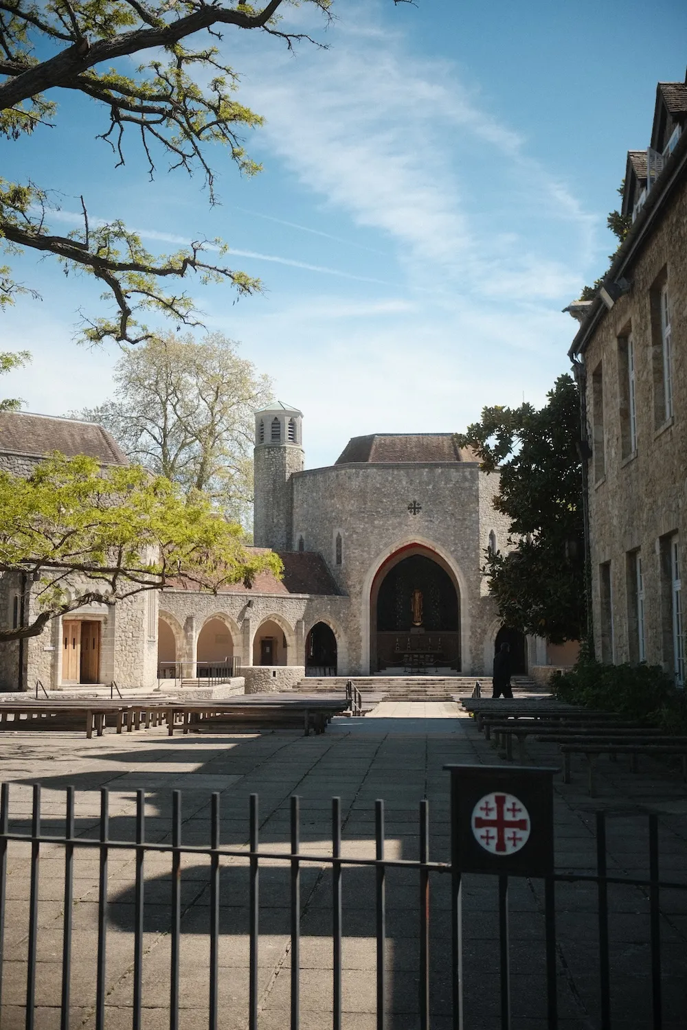 The open-air Shrine at Aylesford Priory seen through the gate, with its cloister arches and bell tower
