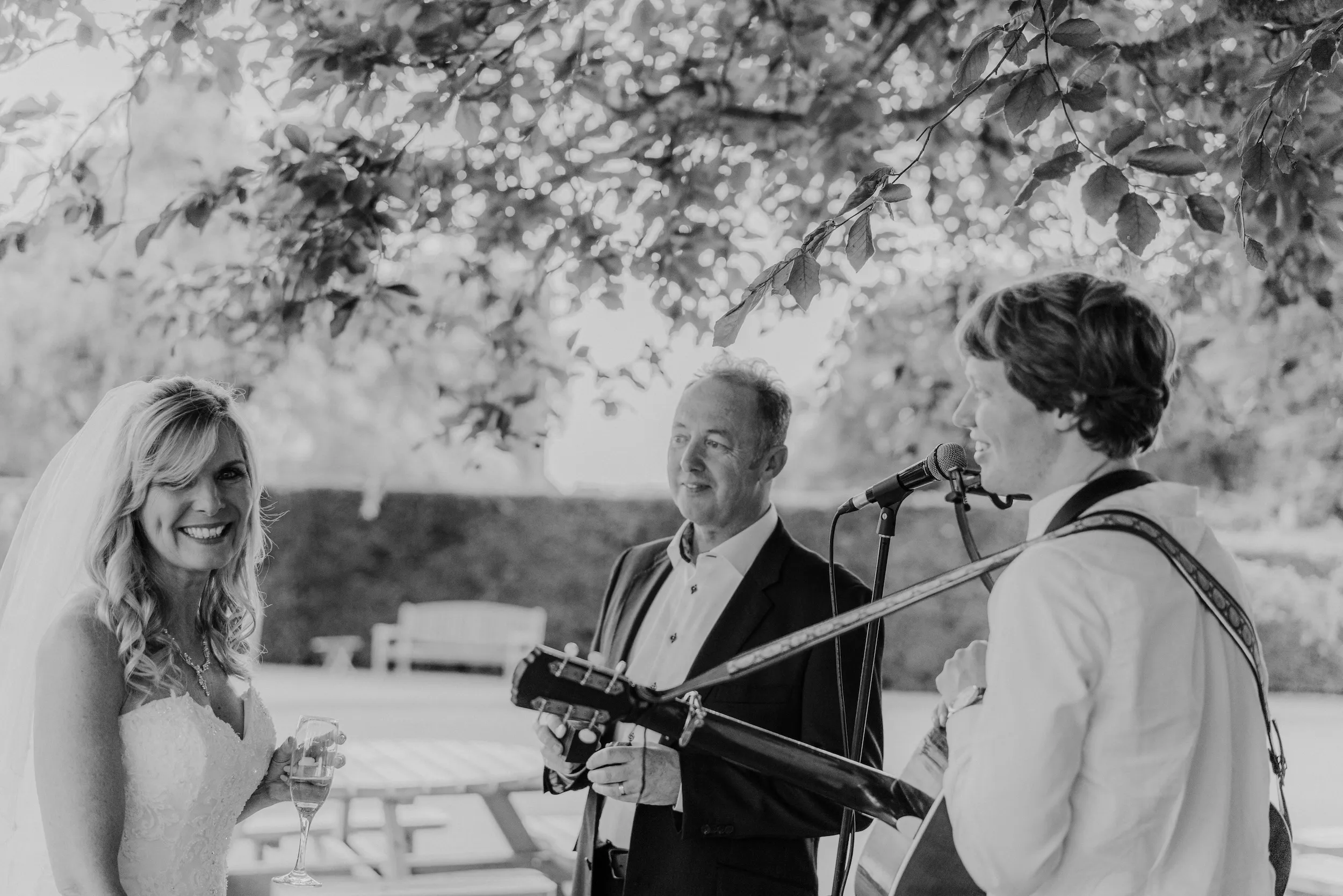 Black and white photograph of Fiona and Mark listening to a singer in the garden