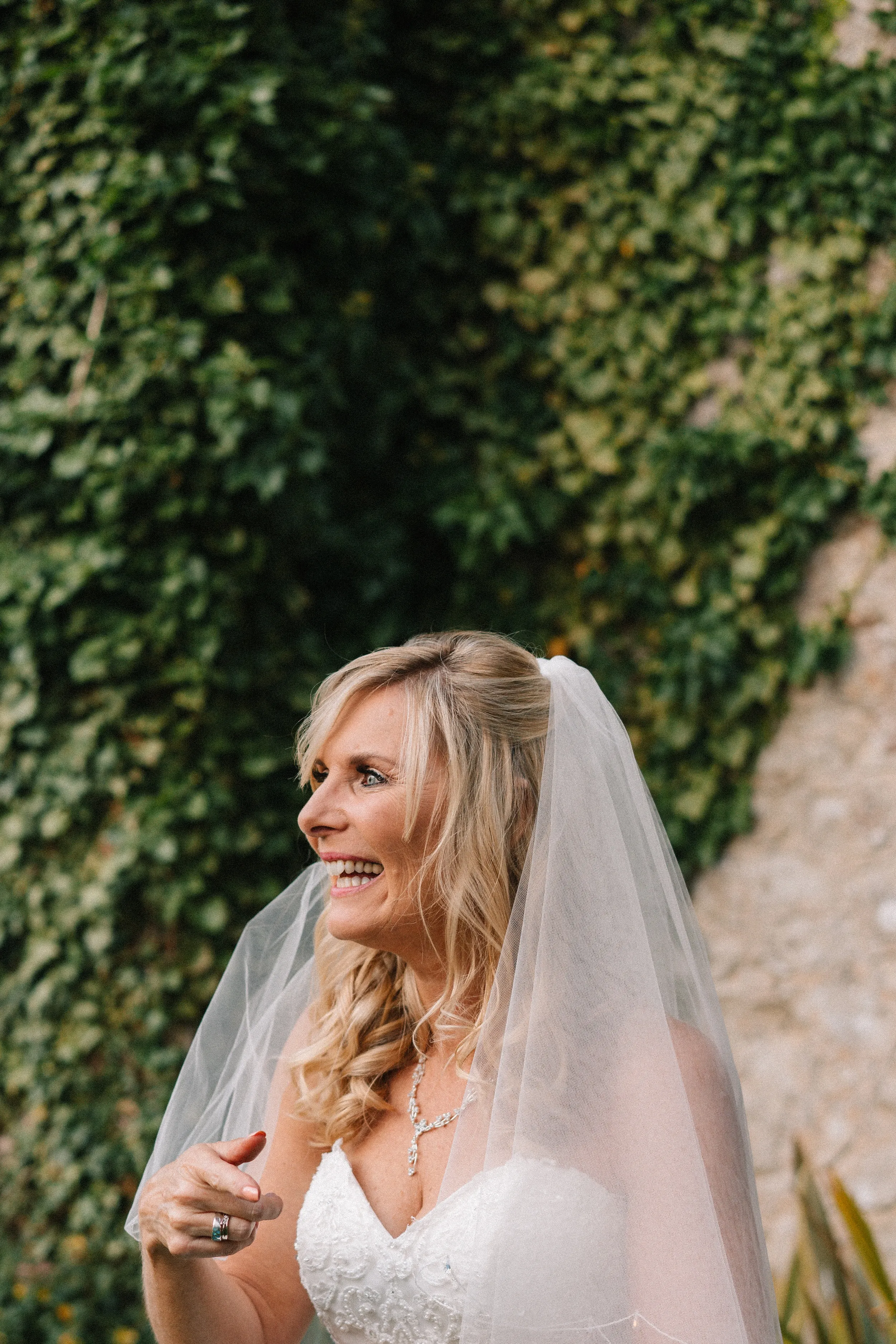 Fiona laughs in front of an ivy-covered wall in the priory gardens