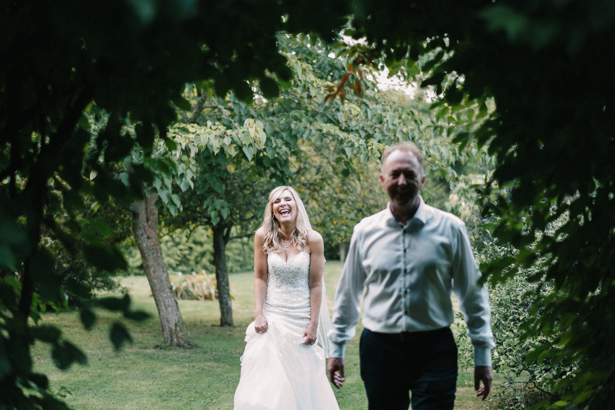 Fiona laughs as she and Mark walk out from under the trees