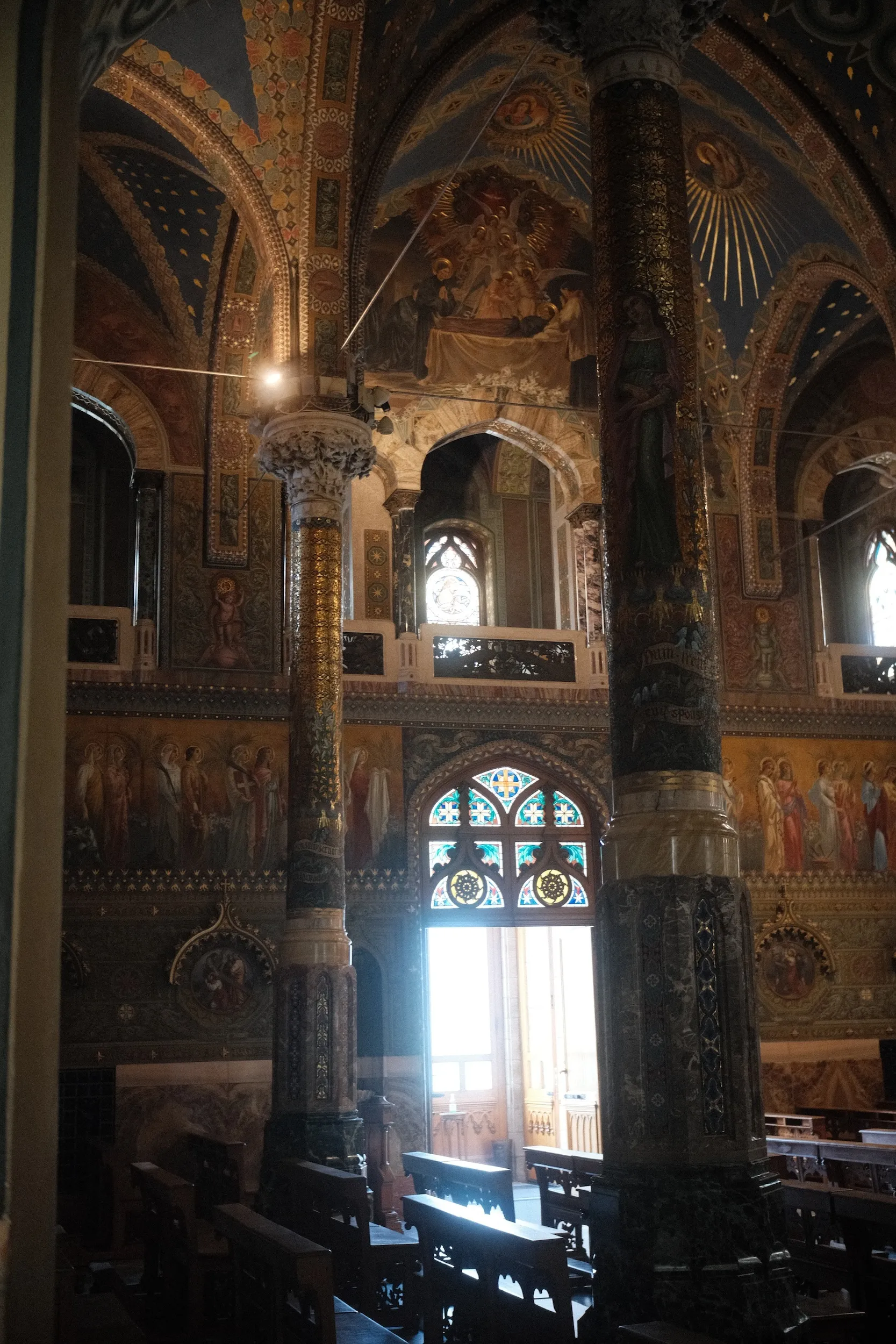 Window light falling down the painted Gothic nave of a church in Italy
