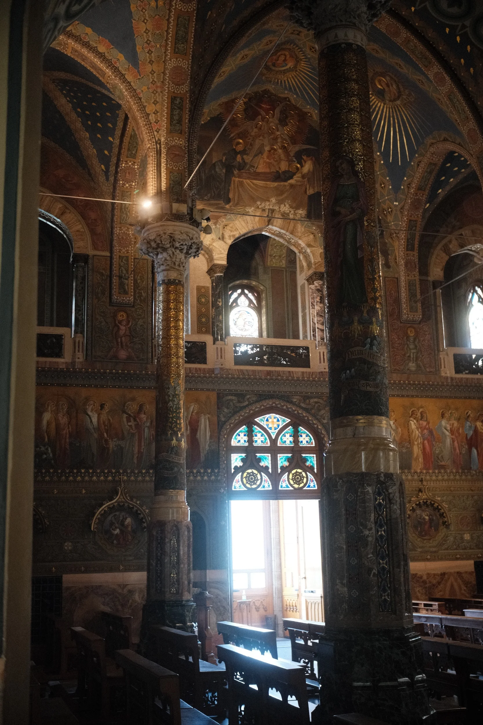 Window light falling down the painted Gothic nave of a church in Italy