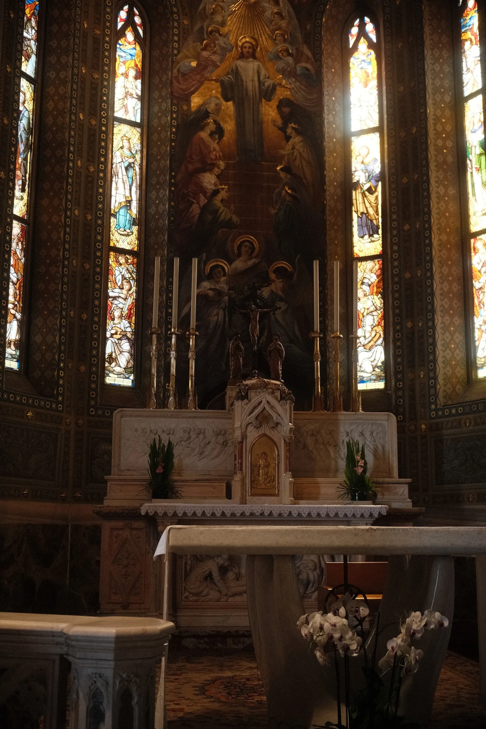 The high altar of a Gothic church, framed by tall stained glass windows