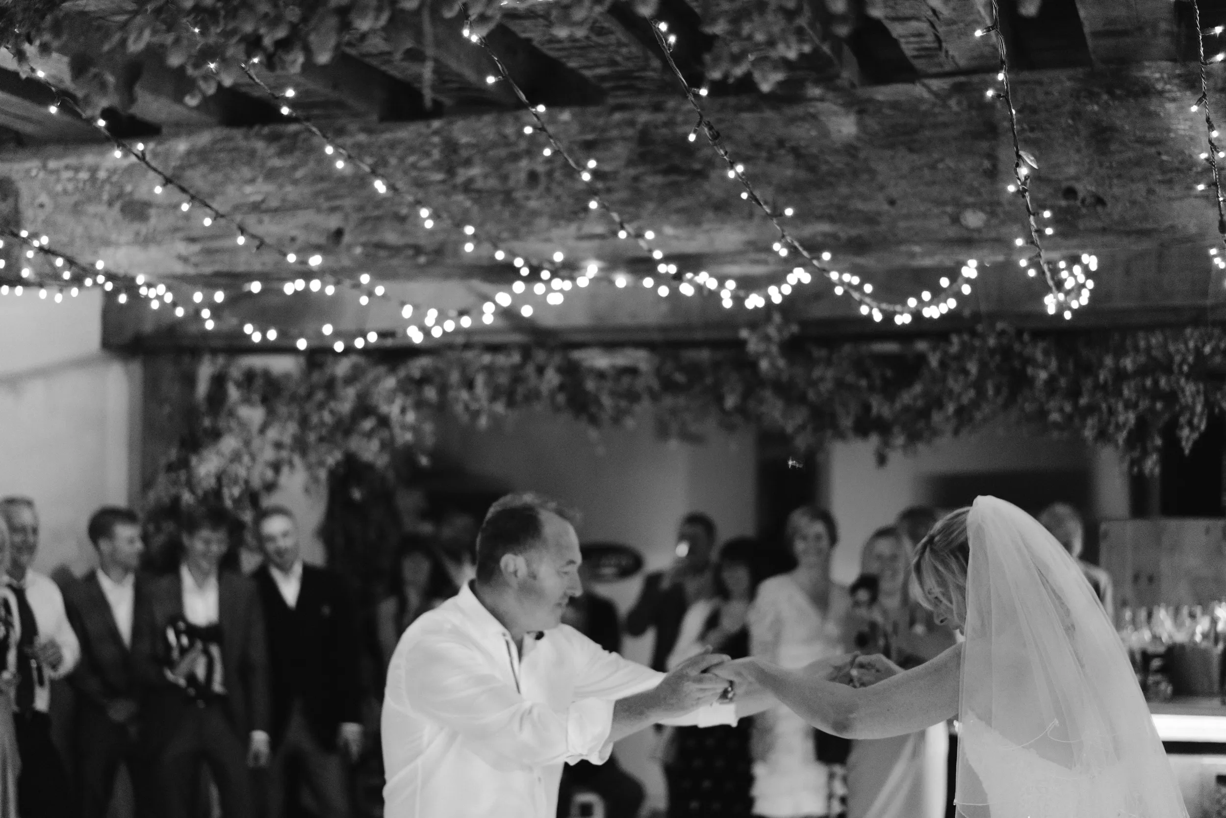 Black and white photograph of Mark and Fiona's first dance under fairy lights