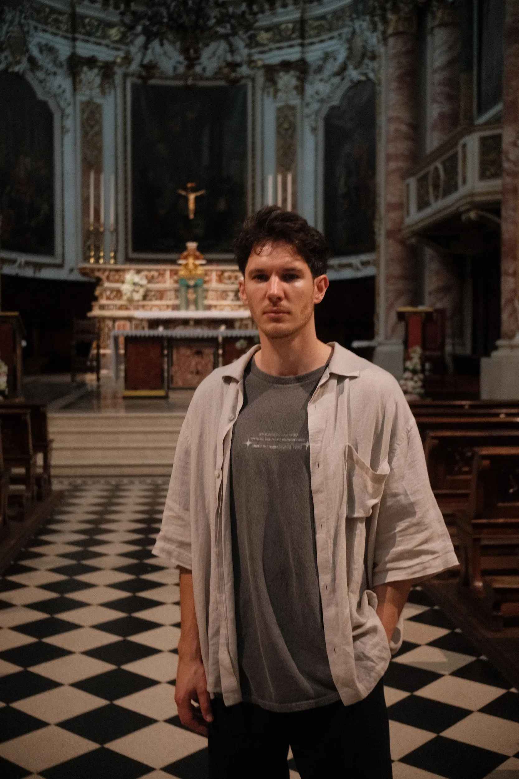 Samuel Austin, Catholic wedding photographer, standing in a church before a gilded high altar