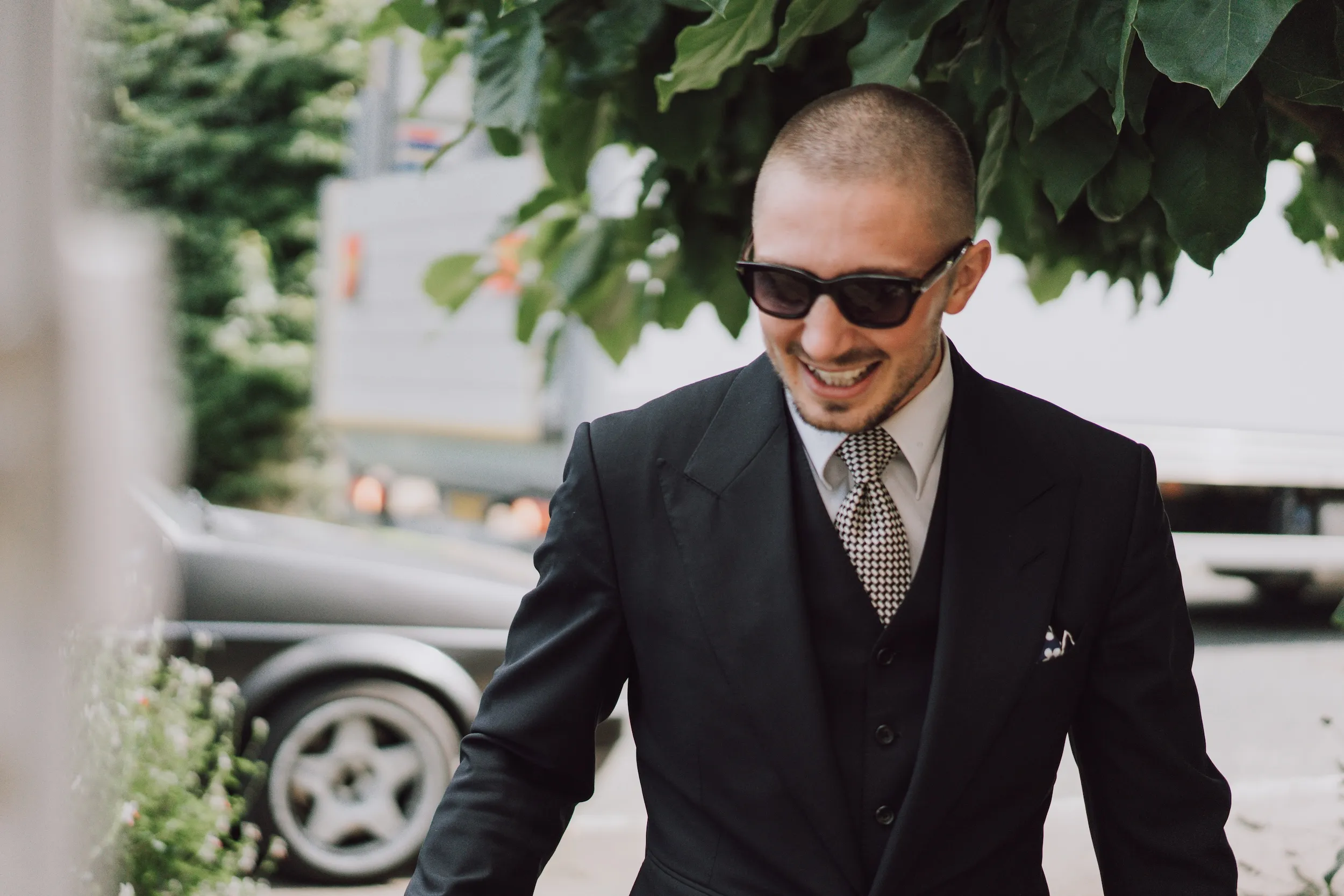 A guest in sunglasses and a three-piece suit arrives at Bilsington Priory